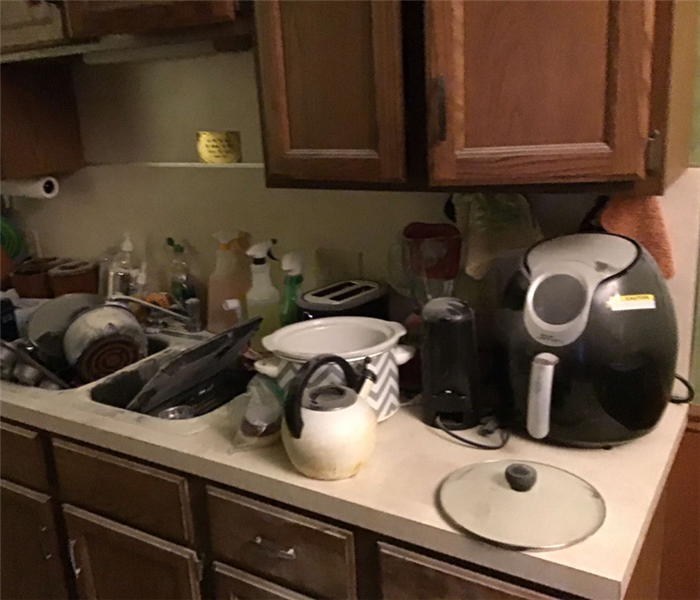 Kitchen counter, sink, and appliances covered in fire extinguisher dust