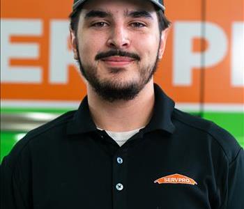 Employee with dark hair and a Servpro hat